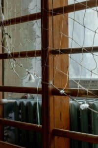 Detailed view of climbing net and wooden bars in an indoor play area, showcasing texture and design.